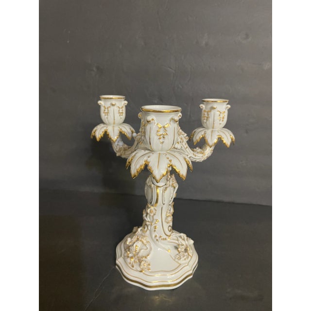 An elegant late 19th-century Continental porcelain three-light candelabrum featuring richly molded Rococo scrollwork,...