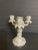 A medium Rocaille style candelabra with 3 candles in white and gilded porcelain. The candlestick was additionally embossed...