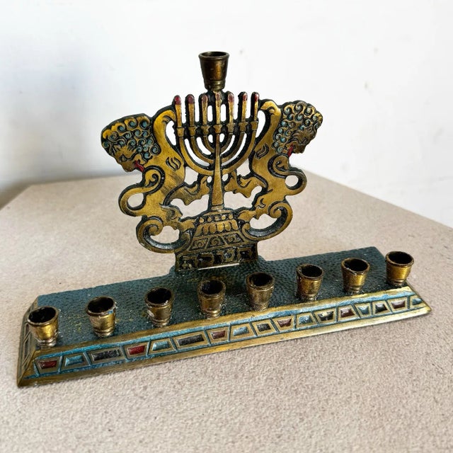 Celebrate heritage with this remarkable brass menorah, featuring the iconic Lions of Judah flanking a central menorah...