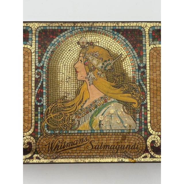 1920 Whitman’s gold-tone Salmagundi tin chocolate box featuring an Alphonse Mucha-style portrait and scrolling Art Nouveau...