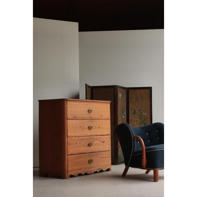 A beautifully restrained Swedish pine chest of drawers dating to the early 20th century, handcrafted with the quiet...