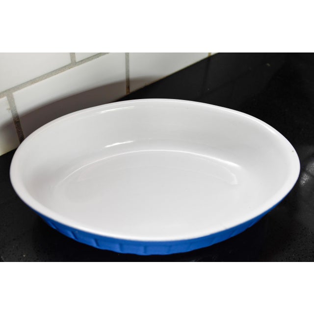 A stunning vintage French oval ceramic baking dish in rich cobalt blue with a white glazed interior. The exterior is...