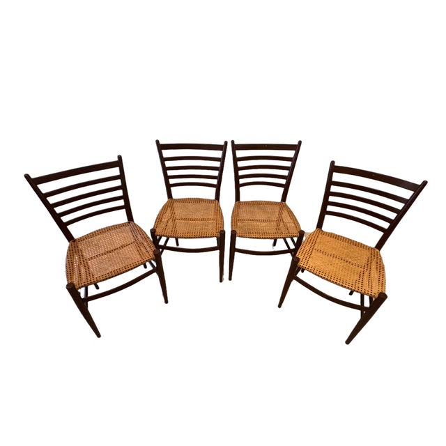 A beautiful set of four vintage Italian dining chairs dating to the 1960s, featuring elegant ladder-back silhouettes and...