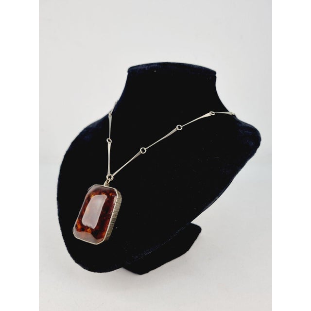 Add a touch of timeless elegance to your collection with this stunning vintage amber pendant necklace from the 1970s. This...