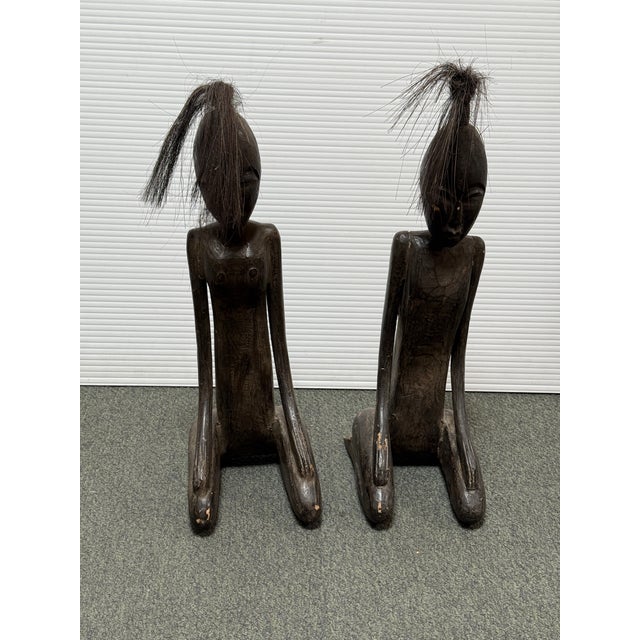 Design Plus Gallery presents a Pair of African Carved Figure Sculptures. Each figure is hand-carved from wood with an...