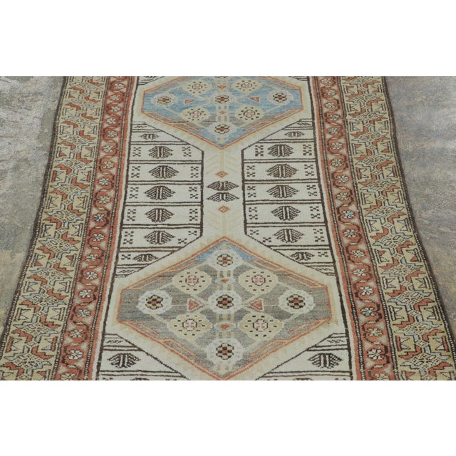 Made with hand-knotted wool circa 1890-1910, this 3x16 antique Persian Sarab extra-long runner enjoys a classic geometric...