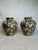 This pair of moderately sized glazed, ceramic ginger jars have a multi faceted design of floral, fruit and insects. The...