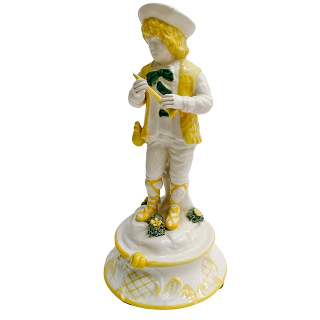 A lovely vintage Italian glazed porcelain figurine in the form of an Italian peasant boy holding a flute. He was hand-...