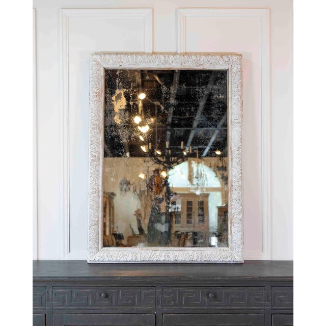 Constructed from wood and stucco, this nineteenth-century French mirror is worked in the Louis XIV style, with moulded...