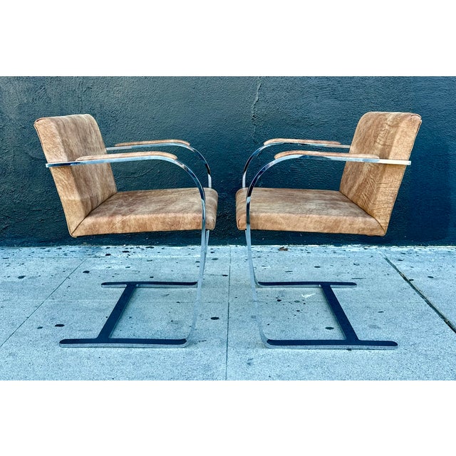 A restored pair of leather and chrome Brno flat bar chairs, designed by Ludwig Mies van der Rohe in 1930 and produced...