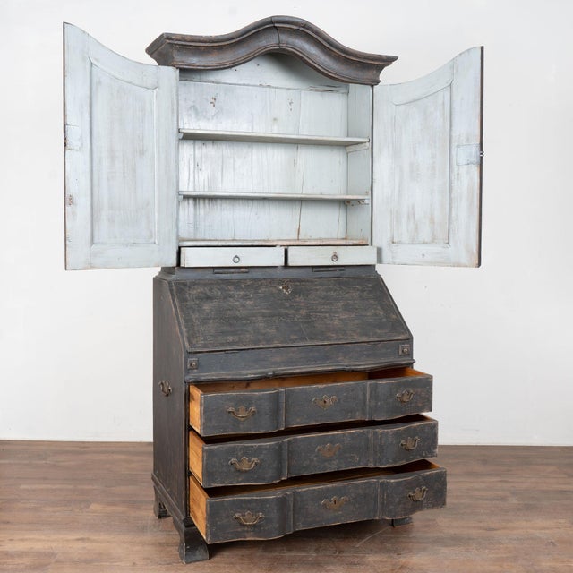 19th century Swedish secretary or "bureau," crafted in pine. The piece has Rococo styling with a curved bonnet crown and...