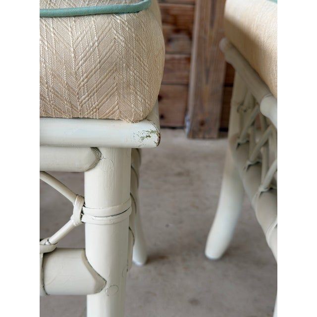 A charming pair of vintage rattan ottomans featuring classic coastal lattice detailing and softly curved legs. These...