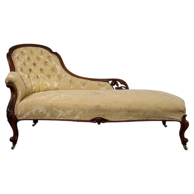 An elegant 19th-century English chaise longue, finely crafted from mahogany and distinguished by its gracefully shaped...