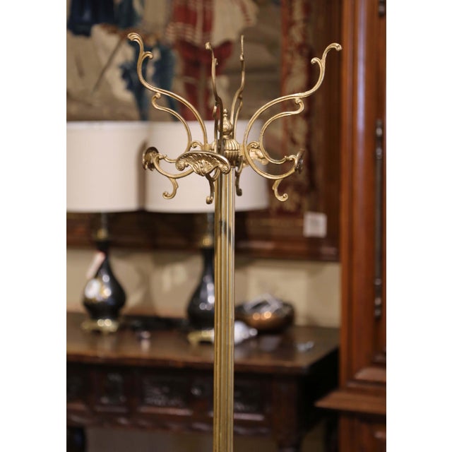 This antique brass and metal free standing halltree was crafted in France, circa 1920. Standing on a tripartite base...