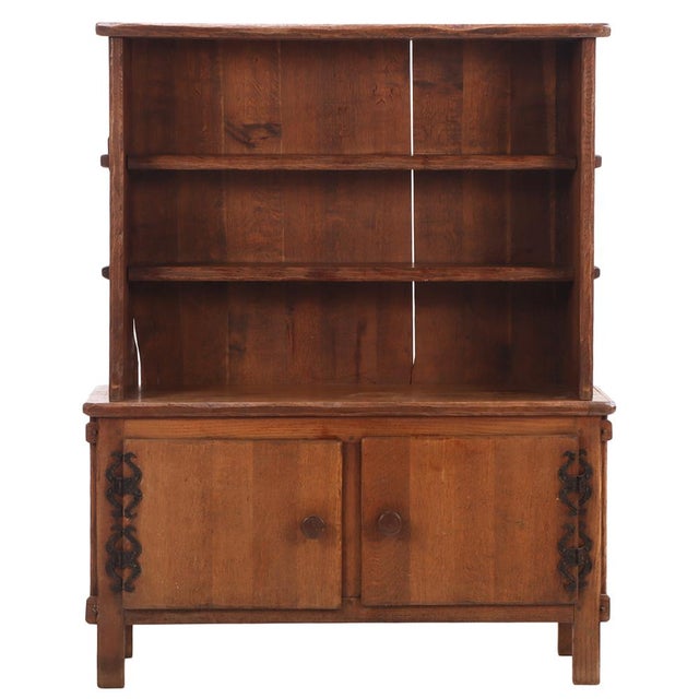 This French Brutalist two-piece cabinet features a richly grained, warm-toned oak construction with a beautifully aged...