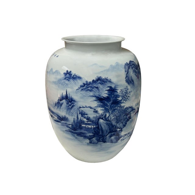 This magnificent porcelain vase presents a captivating blue and white landscape, a quintessential style of Chinese...