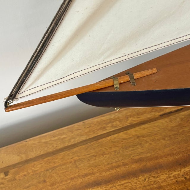 Vintage coastal scale model sailboat, a classic in nautical design. This beautifully rendered model features a dark wood...