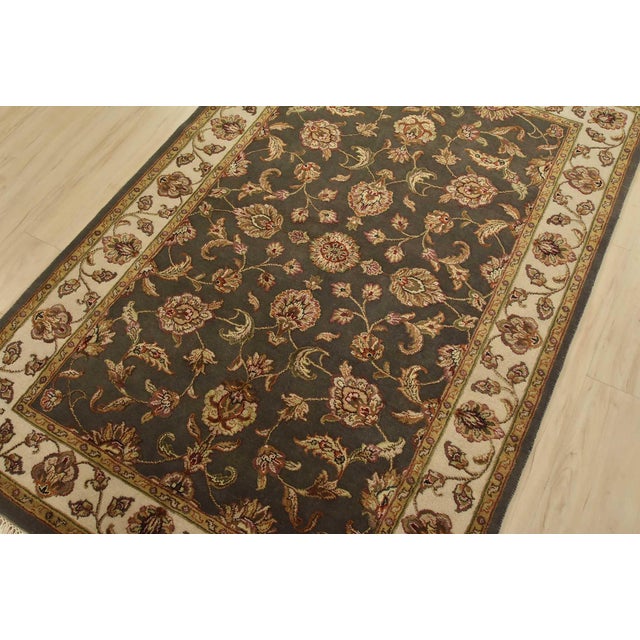 A traditional Agra rug is hand-knotted with a wool and silk pile on a cotton foundation. This finely woven oriental rug...