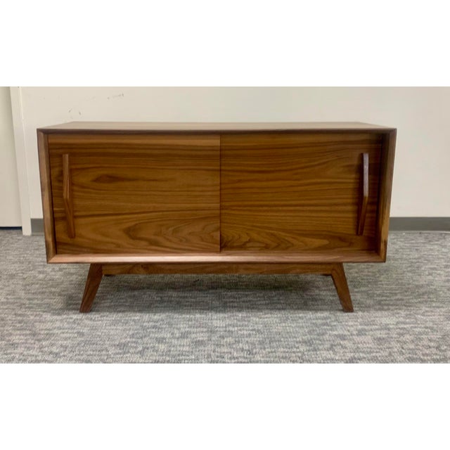 Elevate your space with this stunning Mid-Century Modern walnut credenza, a true testament to clean lines and timeless...