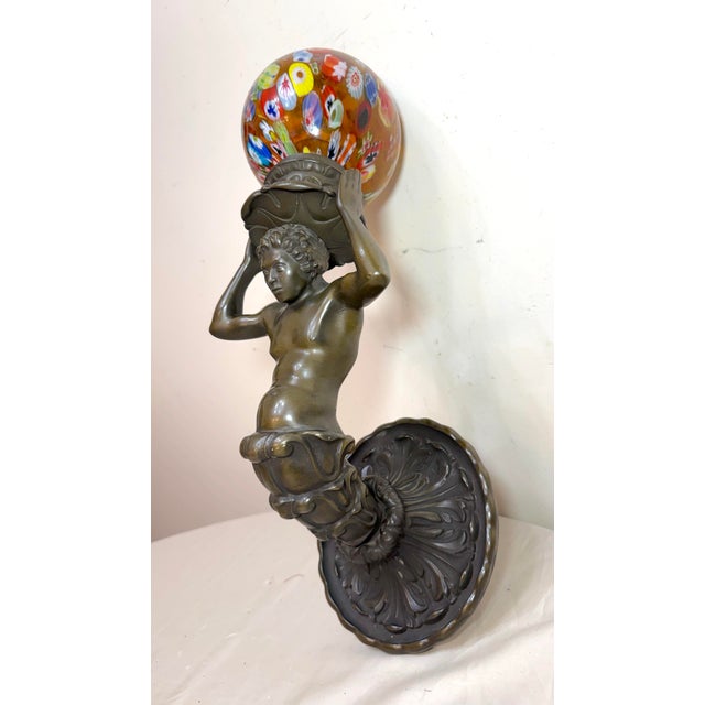 This exquisite antique patinated bronze figural wall sconce with a hand blown millefiori glass shade exudes a classic and...