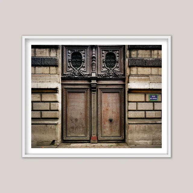 An architectural photograph captures two grand entrance doors of the Louvre Museum in Paris, France. As the world’s most...