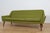 A sofa with a unique contoured shape, produced in Denmark in the 1960s. The sofa has wood armrests from teak wood....