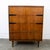 Walnut highboy dresser with 4 drawers. Has a laminate top surface for easy cleaning. Includes brass drawer pulls and black...