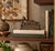 Striking vintage bronze sculpture depicting a reclining Buddha in a serene resting pose atop an elaborately decorated...