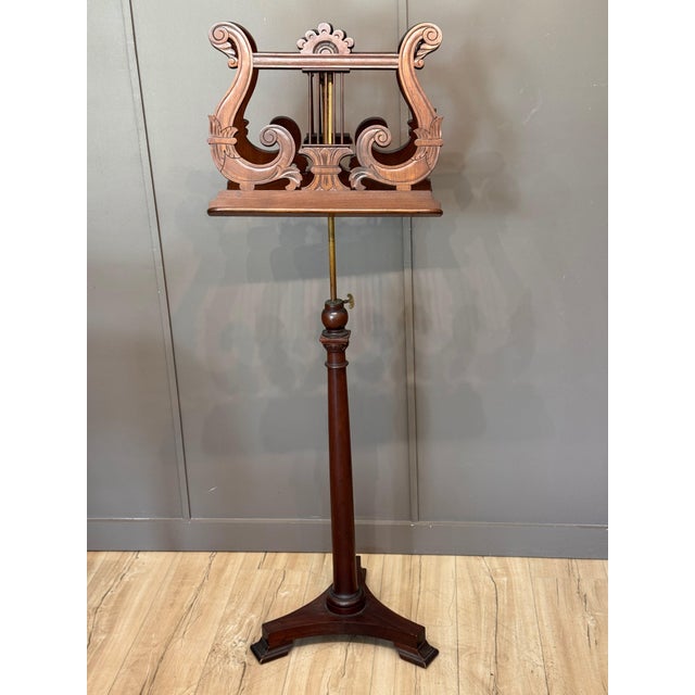 A mid-19th C American mahogany and brass duet stand, the double-sided rests of lyre form with carved facing C-scrolls and...
