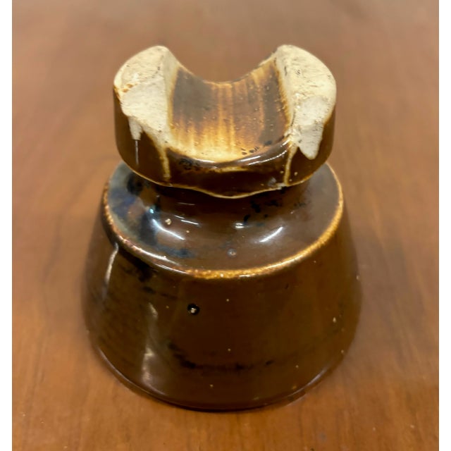 This is a gorgeous antique brown saddle back ceramic glazed insulator with a chip as pictured. Dimensions: - 4 in wide - 4...