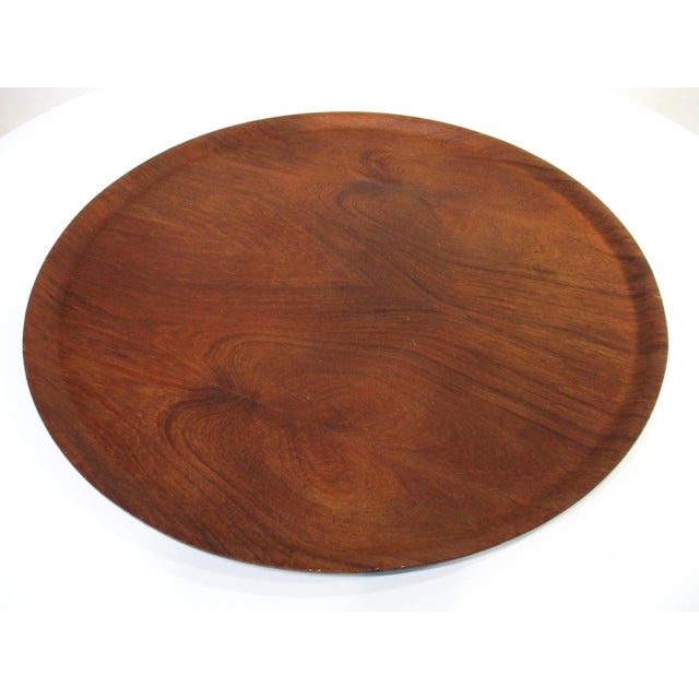 A very large sized molded teak wood tray with an up turned lip which can be used as a center piece or put on an ottoman...