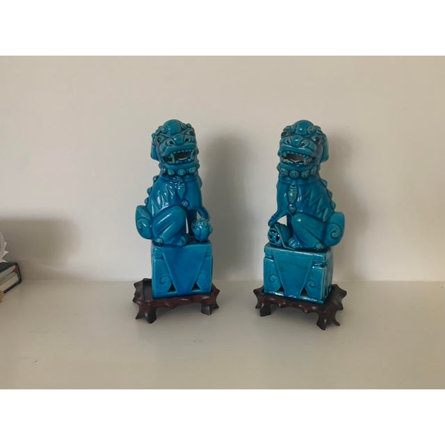 A sweet pair of ceramic foo dogs that fit beautifully in a bookcase or on a side table . The one inch wood stands are...