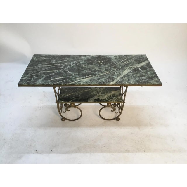Decorative and elegant antique table. Beautiful green and white marble top and lower shelf. Solid brass base.
