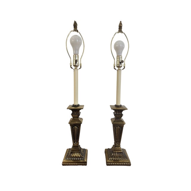 An impressive and substantial pair of vintage solid brass table lamps featuring a bold neoclassical column form with...