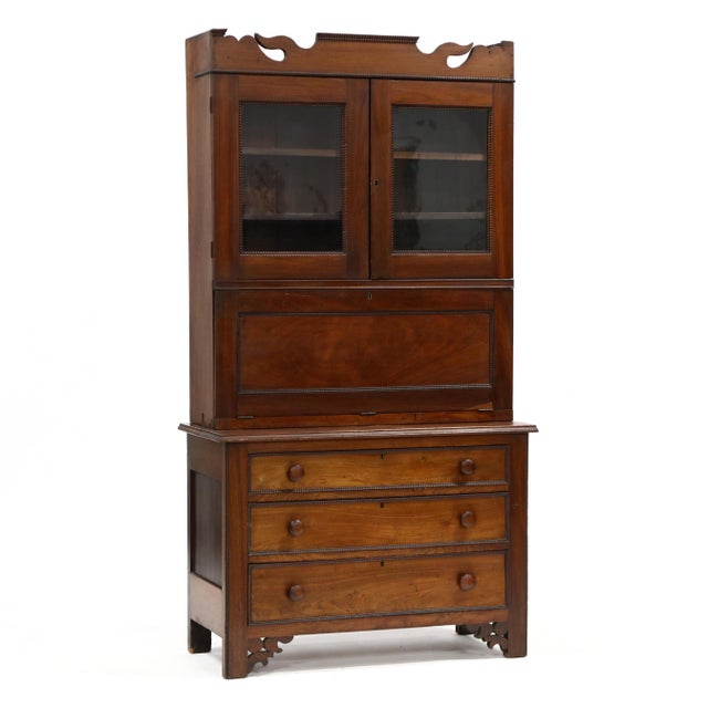 Mid 19th century, poplar and white pine secondary, two-part form, shaped pediment with applied ribboning over two hinged...