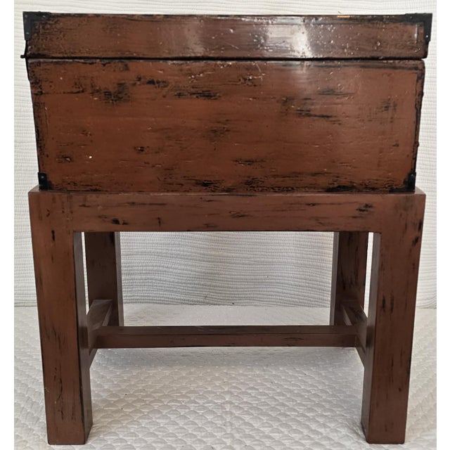 A 19th century wooden box finished in a warm ochre paint with black interior and mounted on a simple, integrated wooden...