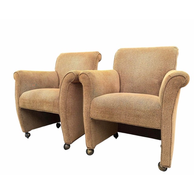 A handsome pair of vintage English-style rolled arm club chairs with a classic, understated silhouette. The chairs feature...