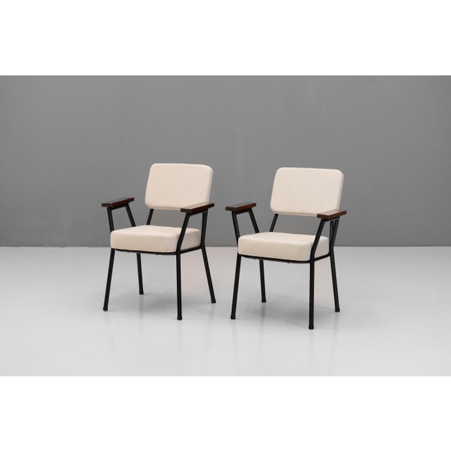 Pair of mid-century steel framed side chairs by T Murphy. with solid teak square arms and recovered in a beige linen....