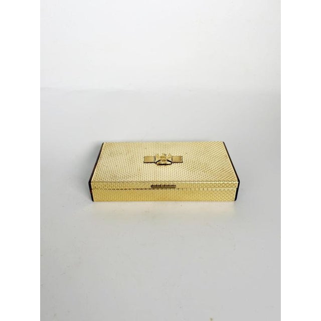 Elegant French decorative box combining a textured gold-tone metal exterior with warm tortoiseshell-effect Bakelite side...
