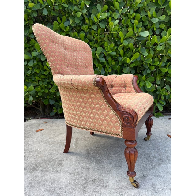 A handsome Hickory Chair Edwardian Club Chair featuring a richly finished mahogany frame, deep button tufting, and brass...