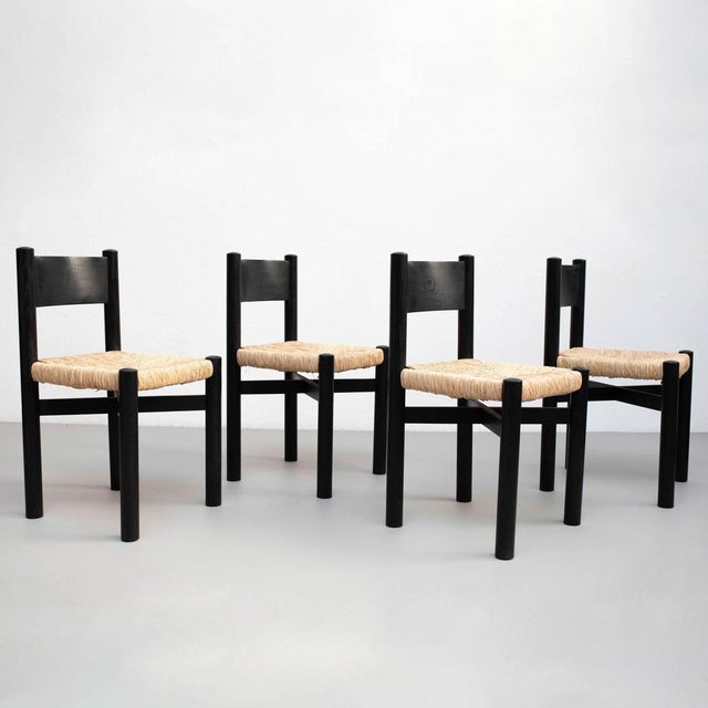Set of Four Wood and Rattan Chairs After Charlotte Perriand – Circa 1980 This set of four chairs, inspired by the timeless...