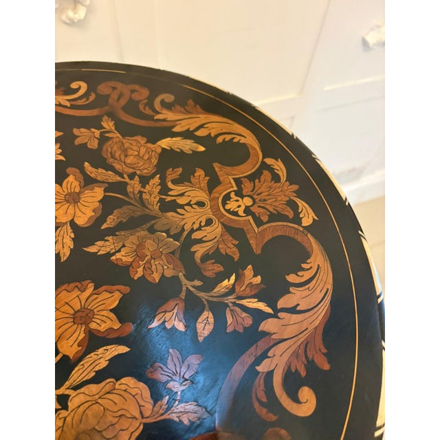 A very elegant antique pedestal occasional table beautifully crafted in ebonised wood and richly decorated with intricate...