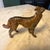 Vintage bronze-finished metal dog figurine depicts a slender, long-haired breed such as a Borzoi, Saluki, or Greyhound....