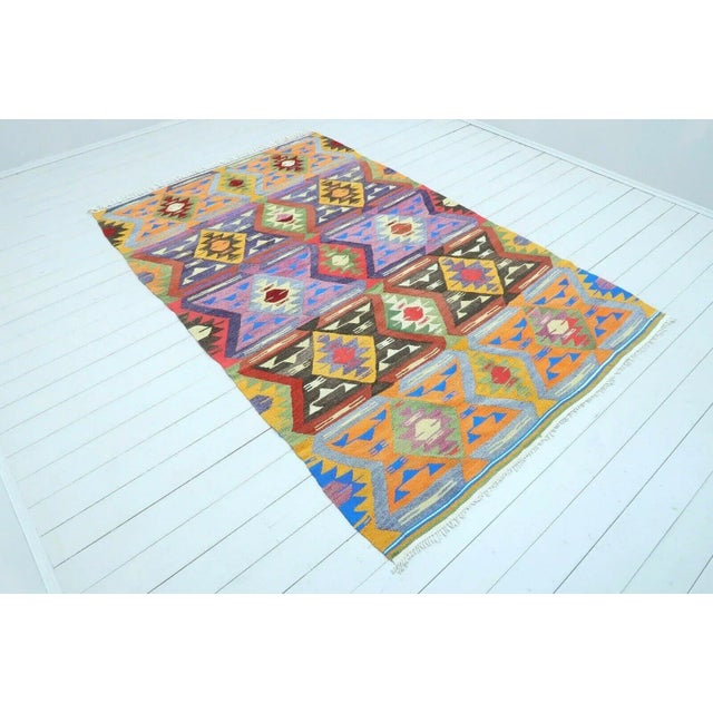 This beautiful, traditional vintage, flatweaved Turkish kilim rug is approximately 60 years old. It is handmade of very...