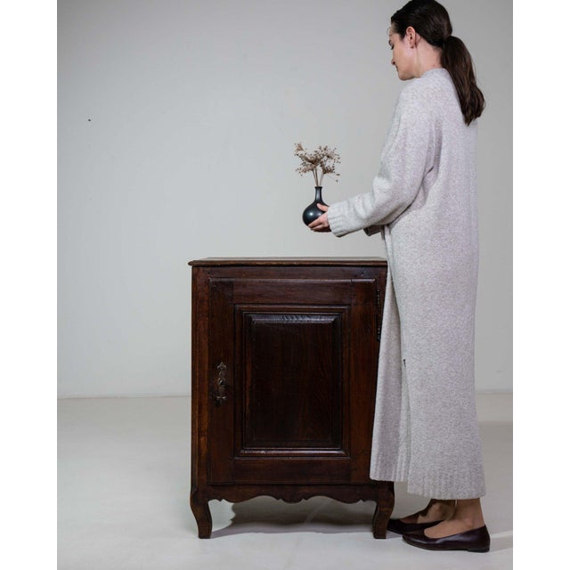 This side cabinet carries genuine presence, its dark walnut, single door, open shelf immediately setting the tone for the...