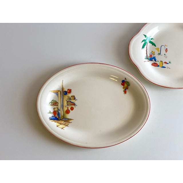 Set of two “Sleeping Mexican” serving plates. The larger plate depicts a man sitting a along a kitchen wall and fruit...