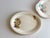 Set of two “Sleeping Mexican” serving plates. The larger plate depicts a man sitting a along a kitchen wall and fruit...