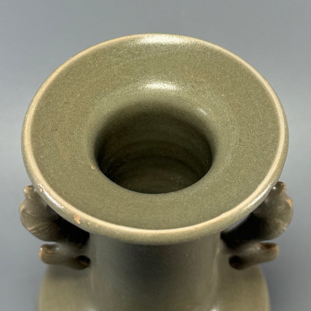 This antique Chinese Longquan celadon vase is decorated with beautifully sculpted dragon handles on both sides. It has a...