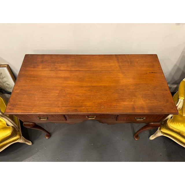 This is an American antique Queen Anne style lowboy. The drawers are tiger maple and the body is walnut.. There are three...