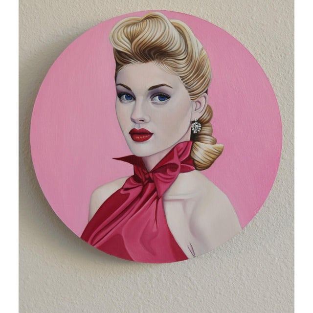 This artwork features a striking portrait of a woman set against a vibrant pink background, which enhances her classic...